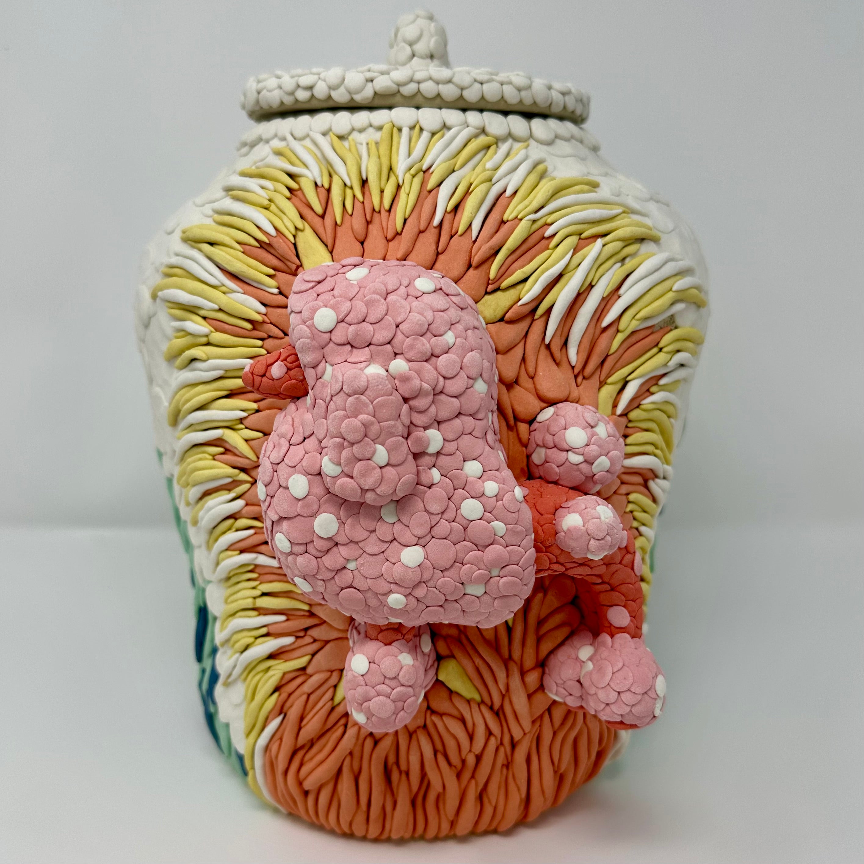 Decorative ceramic jar with colorful designs on a white background